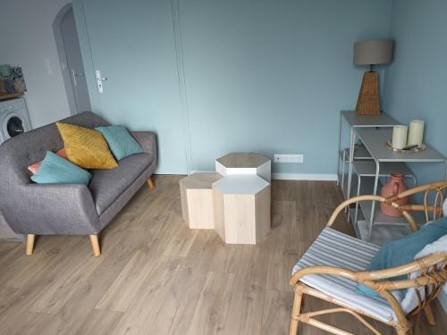un salon avec un canapé et une chaise dans l'établissement Tregastel 300m des plages, à Trégastel