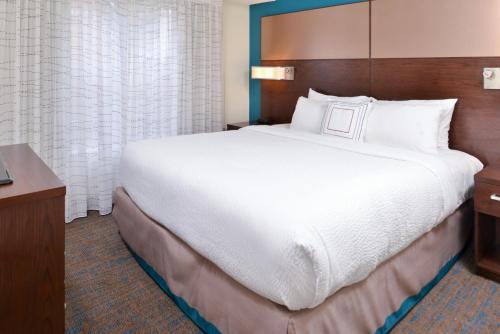 a hotel room with a large bed and a desk at Residence Inn by Marriott Branson in Branson
