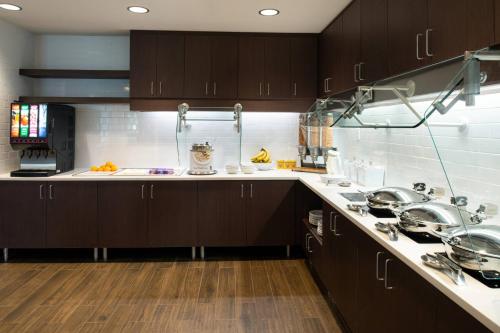 a kitchen with brown cabinets and white counter tops at Residence Inn by Marriott St Louis Chesterfield in Chesterfield