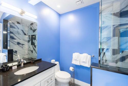 a blue bathroom with a sink and a toilet at Keys Please! in Key West