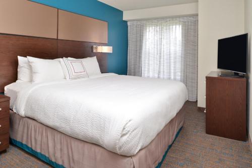 a hotel room with a large bed and a flat screen tv at Residence Inn by Marriott Branson in Branson