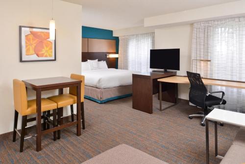 a hotel room with a bed and a desk with a computer at Residence Inn by Marriott Branson in Branson