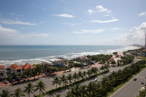 an aerial view of a street with palm trees and the ocean at Diamond Sea Hotel in Da Nang