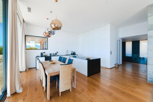 une cuisine et une salle à manger avec une table et des chaises dans l'établissement Villa SUNSET- 5 chambres, piscine et vue mer, à Porticcio