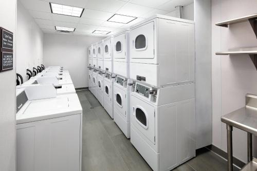 a laundry room with white washing machines and sinks at Residence Inn by Marriott San Jose Cupertino in Cupertino