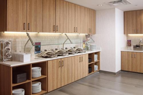 a kitchen with wooden cabinets and white plates and dishes at Residence Inn by Marriott San Jose Cupertino in Cupertino