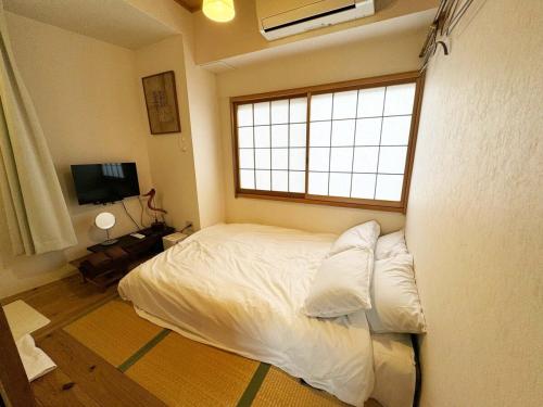 a bedroom with a white bed and a window at Time Camp 高輪 in Tokyo