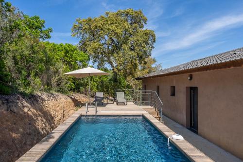 - une piscine avec une terrasse et un parasol dans l'établissement Les Villas de Lorello, à Porticcio