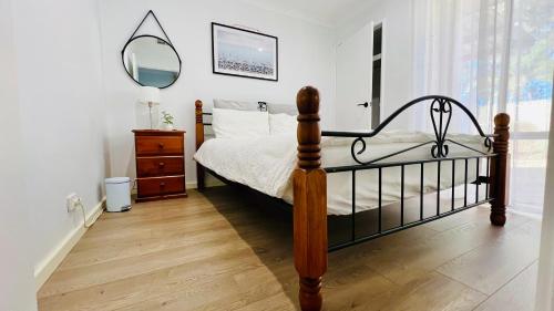 a bedroom with a bed with a mirror and a dresser at Beautiful home Queen bed near train station in Cockburn Central