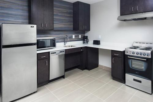 a kitchen with white appliances and brown cabinets at Residence Inn by Marriott Knoxville Downtown in Knoxville