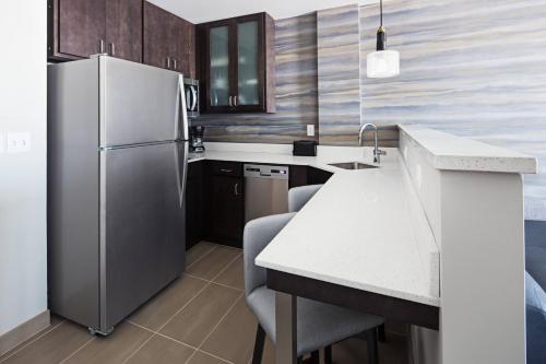 a kitchen with a refrigerator and a table and chairs at Residence Inn by Marriott Knoxville Downtown in Knoxville