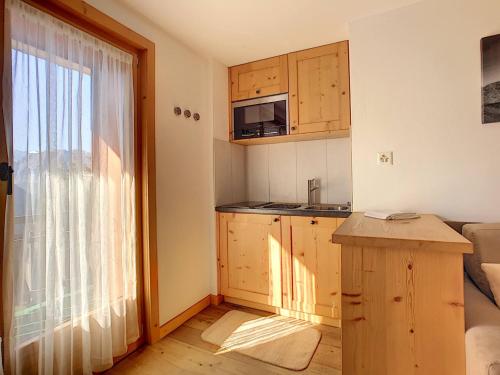 a small kitchen with wooden cabinets and a window at Asters 6 in Verbier