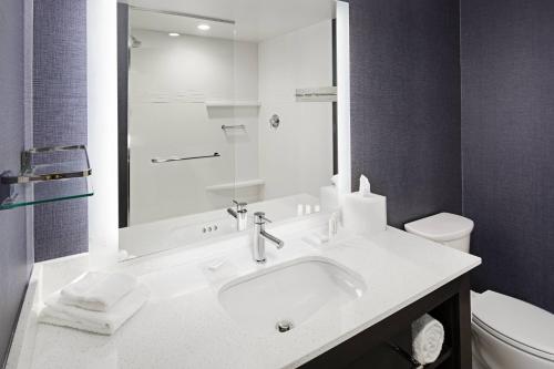a white bathroom with a sink and a toilet at Residence Inn by Marriott Knoxville Downtown in Knoxville