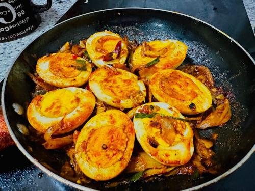a pan filled with fried potatoes and onions at Ella Elysium Escapes in Ella