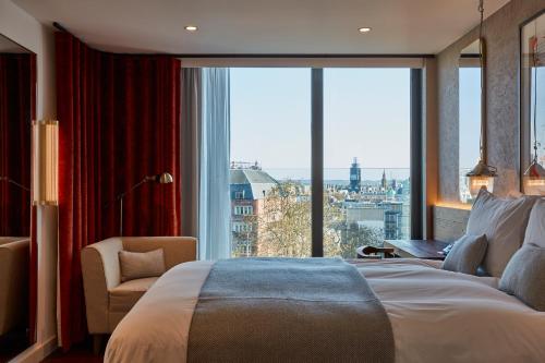 a bedroom with a bed and a large window at Hotel Indigo London - 1 Leicester Square by IHG in London