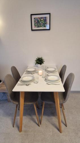 a white table with chairs and plates on it at Ferienwohnung Grenzenblick in Bayerisch Eisenstein