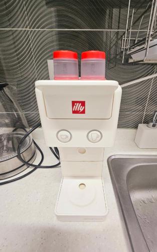 a white appliance with two cups on top of a sink at 로맨틱 프라이빗 테라스, 무료주차, 2룸 in Daegu