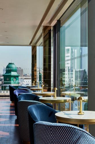 a restaurant with tables and chairs and a view of the city at Hotel Indigo London - 1 Leicester Square by IHG in London
