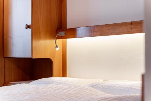 a bedroom with a white bed with a wooden headboard at Hotel Parnass in Zermatt