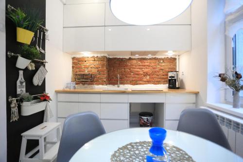 a kitchen with a table and chairs and a brick wall at CERONAV CityCenter - DisneyTV!! in Galaţi