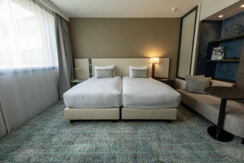 a hotel room with a bed and a couch at Residence Inn by Marriott Toulouse-Blagnac in Blagnac