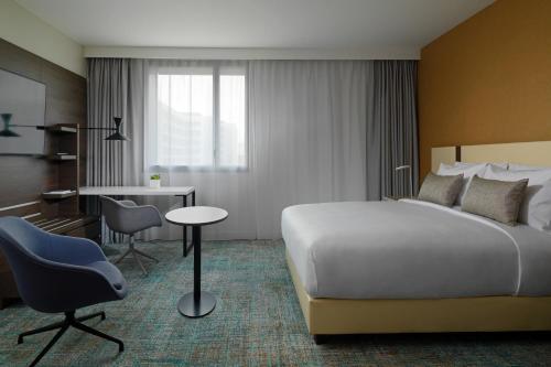 a hotel room with a bed and a desk at Residence Inn by Marriott Toulouse-Blagnac in Blagnac
