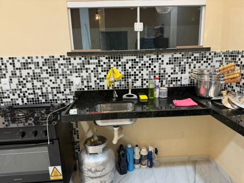 eine Küchentheke mit einer Spüle und einem Herd in der Unterkunft Linda Casa Aconchegante Aquiraz in Aquiraz