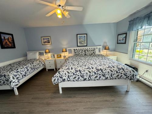 a bedroom with two beds and a ceiling fan at Gingerbread House Inn - We Are Open - Winter, Spring, Summer and Fall in Wolfville