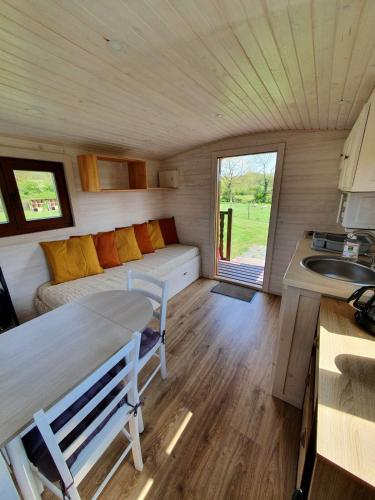 Elle comprend un petit salon doté d'un canapé et d'un lavabo. dans l'établissement La roulotte de Rochavelle, à Chiché