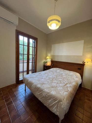 a bedroom with a large bed and a window at Il Glicine in Villasimius