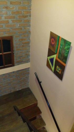 a painting hanging on a wall next to a set of stairs at Casa 24 Puerto Iguazu in Puerto Iguazú
