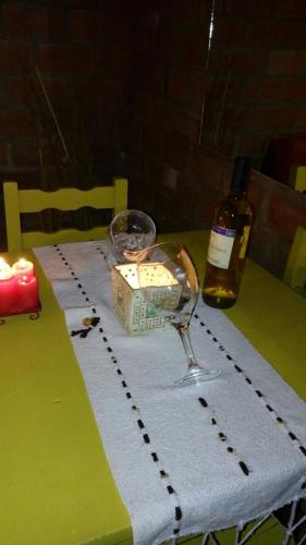 a table with a wine glass and a bottle of wine at Casa 24 Puerto Iguazu in Puerto Iguazú