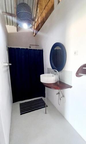 a bathroom with a sink and a blue shower curtain at Baobab Beach Vilanculos in Vilanculos