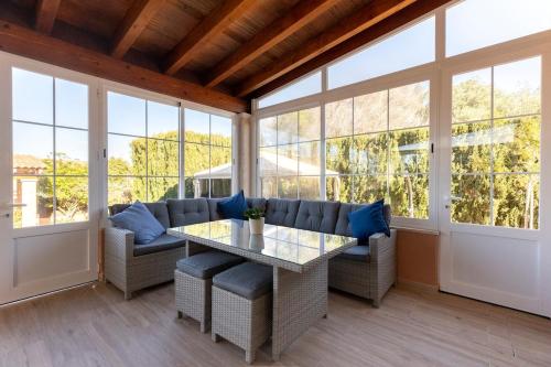 a screened in porch with a table and blue pillows at Mallorca Casa Mar Blava in Llucmajor