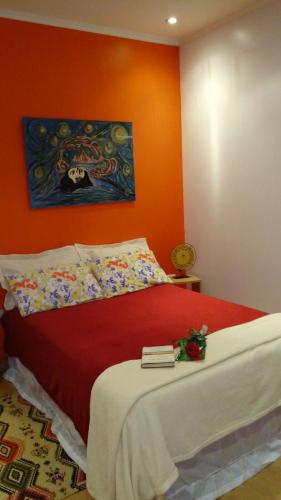 a bedroom with a bed with an orange wall at Casa 24 Puerto Iguazu in Puerto Iguazú