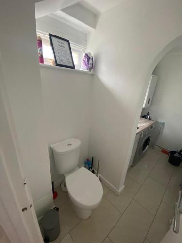 a white bathroom with a toilet and a sink at Spacious Home, Garden, in Harlow, Comfy for Contractors & Relocators in Great Parndon