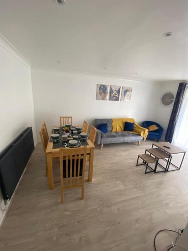 a living room with a table and chairs and a couch at Spacious Home, Garden, in Harlow, Comfy for Contractors & Relocators in Great Parndon