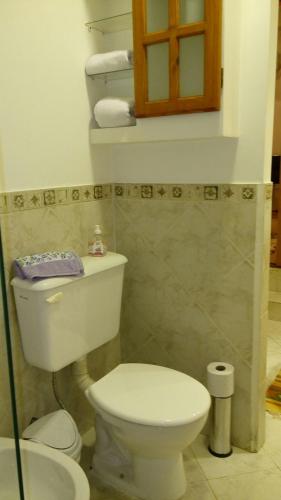 a bathroom with a white toilet and a sink at Casa 24 Puerto Iguazu in Puerto Iguazú