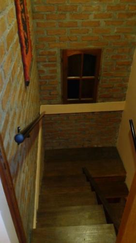 a staircase with a brick wall and a window at Casa 24 Puerto Iguazu in Puerto Iguazú