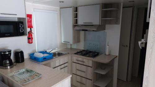 波讷地区圣朱利安Mobil home 8 personnes 3 chambres的带水槽和炉灶的小厨房
