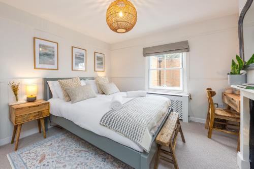 une chambre avec un grand lit et un bureau dans l'établissement Charming 2 Bed Cottage - within city walls - free parking- garden, à Canterbury