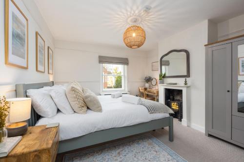 a bedroom with a bed and a table and a fireplace at Charming 2 Bed Cottage - within city walls - free parking- garden in Canterbury