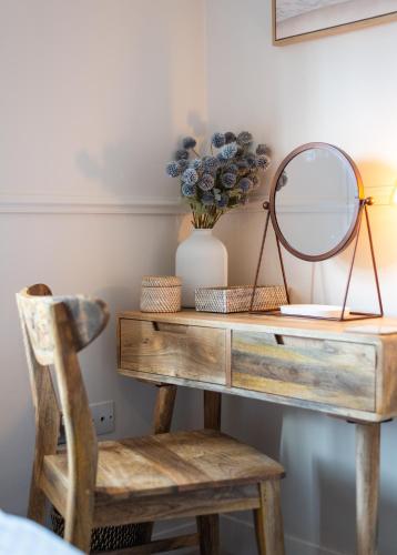 a dressing table with a mirror and a chair at Charming 2 Bed Cottage - within city walls - free parking- garden in Canterbury