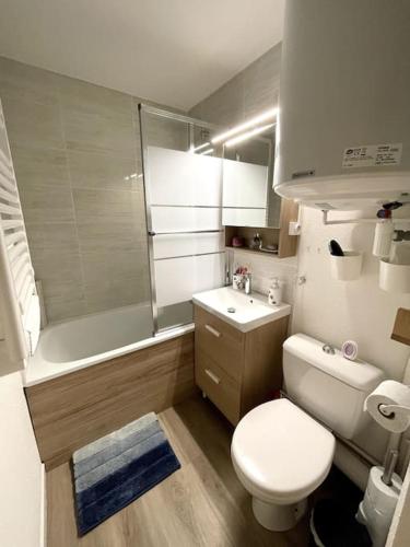 une salle de bain avec toilettes, lavabo et baignoire dans l'établissement T2 Vue Mer à 30m de la Plage, à Villers-sur-Mer