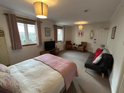 a bedroom with a bed and a couch at Elderslie Guest House in Oban