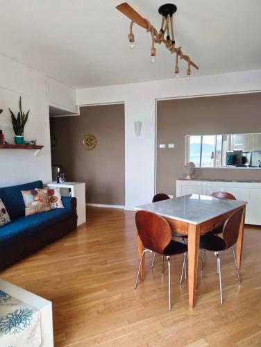 a living room with a table and chairs and a couch at Il Balcone sul mare - free parking & relax in Palermo