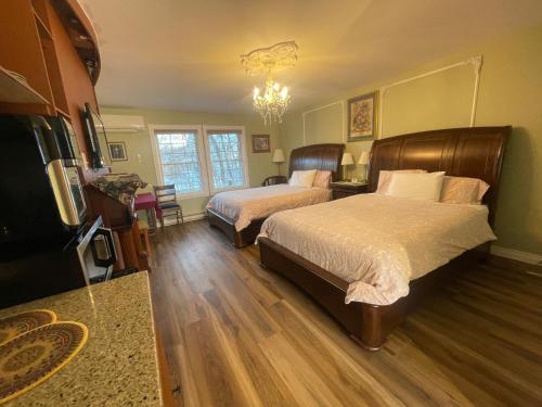 a bedroom with two beds and a flat screen tv at Gingerbread House Inn - We Are Open - Winter, Spring, Summer and Fall in Wolfville