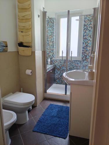 a bathroom with a toilet and a sink and a shower at Il Balcone sul mare - free parking & relax in Palermo
