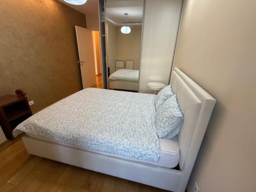 a small bedroom with a bed and a mirror at Central Garden modern 1 bedroom condominium complex in Belgrade