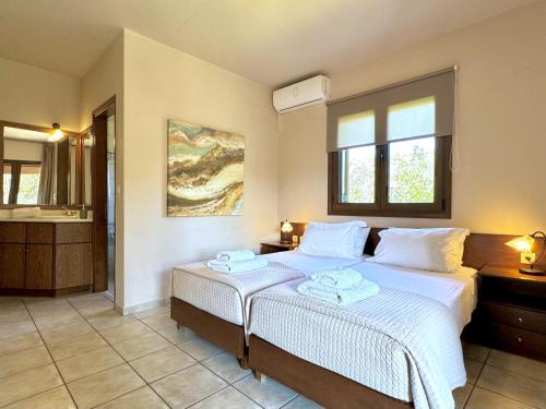 a bedroom with a bed with two towels on it at Villa Metapothia Gavalochori Crete in Gavalochori